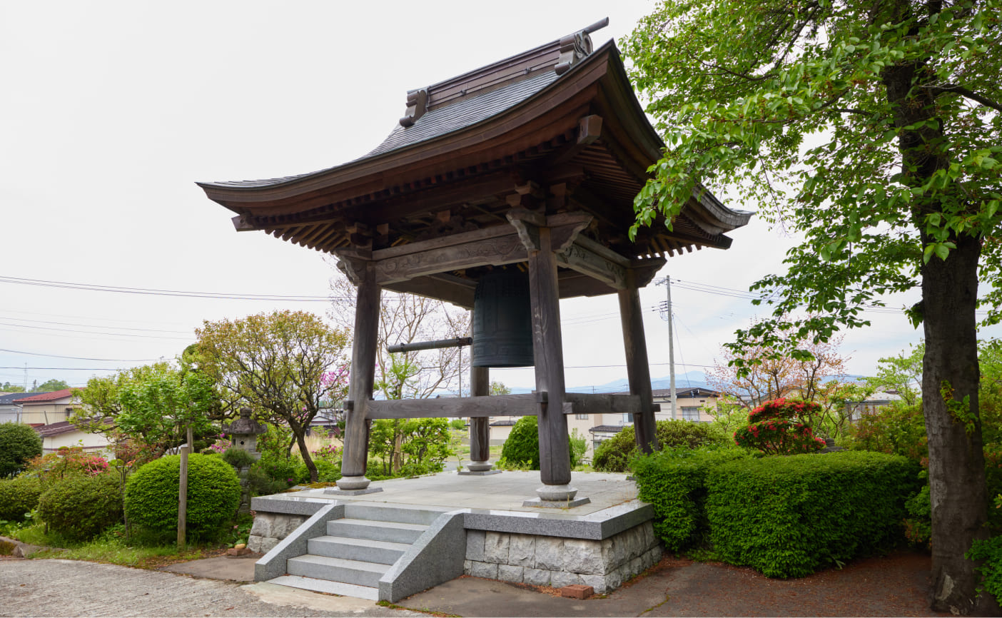 雄山寺の伝統的な鐘楼と周囲の緑